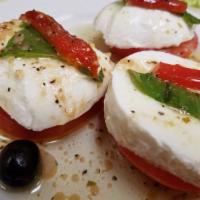 Caprese Salad · Fresh mozzarella cheese, sliced tomatoes, onions and basil.