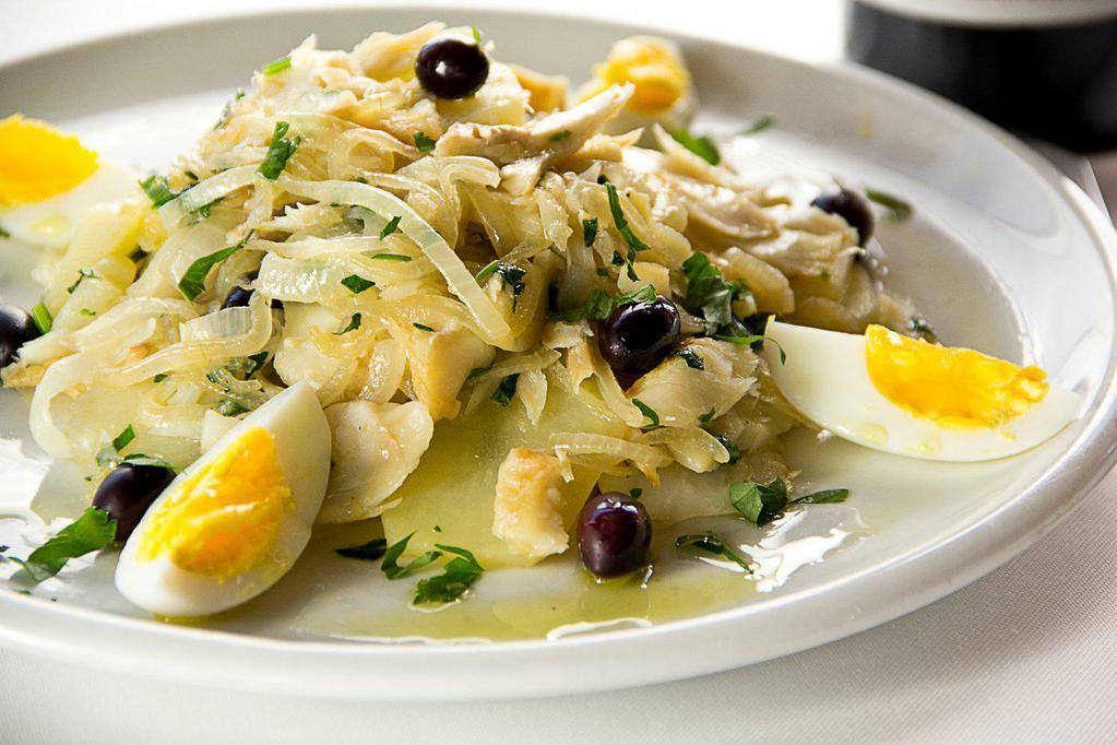 Bacalhao a lagareiro · Baked codfish steak with onions, Portuguese olive oil, potatoes, vegetable.