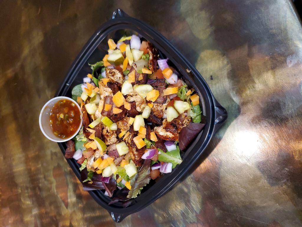 Joe's Chopped Salad · Marinated chicken breast with bacon, tomatoes, onions, pickles and carrots on a bed of mixed greens served with a tomato bacon vinaigrette.