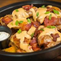 Loaded Fried Smashed Potatoes · Our fried smashed potatoes topped with nacho cheese sauce, bacon, scallions and sour cream.