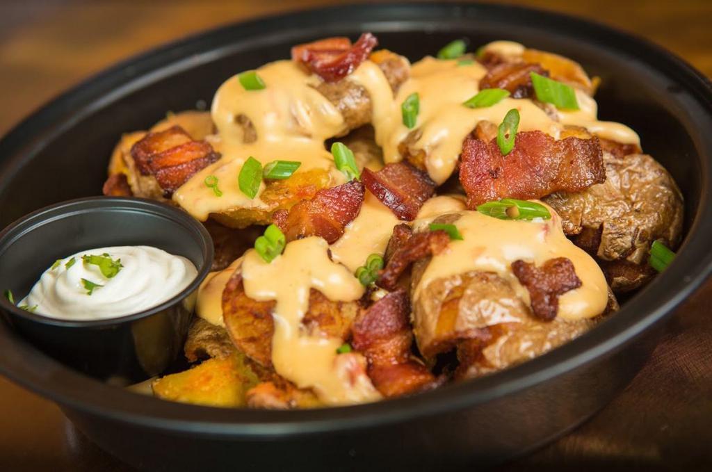 Loaded Fried Smashed Potatoes · Our fried smashed potatoes topped with nacho cheese sauce, bacon, scallions and sour cream.