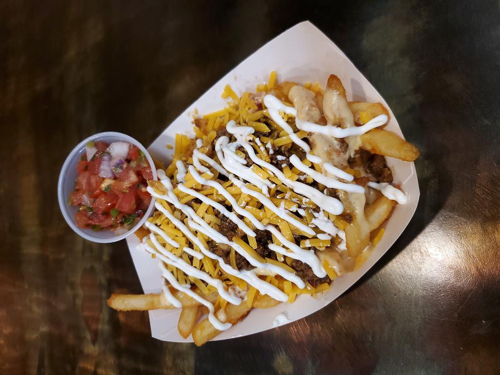 Taco Fries · French fries topped with our taco beef and nacho cheese sauce with a drizzle of sour cream and a side of pico de gallo.