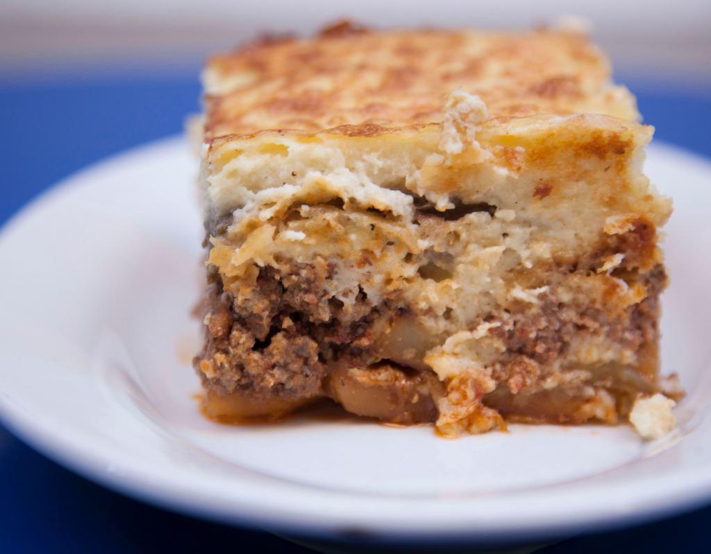Moussakas · Traditional Greek casserole with bechamel sauce, ground beef, eggplant and potatoes.