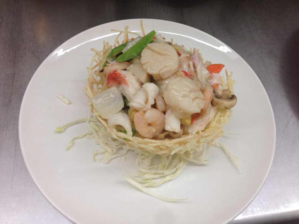 Birds Nest Delicacies 鸟巢 · Shrimp, scallop and crab meat sauteed in special white sauce with assorted vegetables contained in a artistic nest made of potatoes.