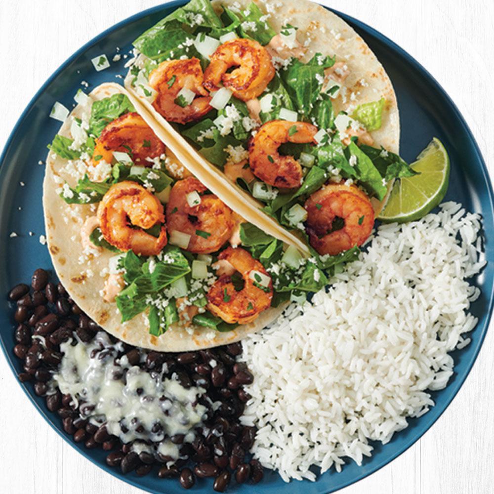 Chipotle Garlic Shrimp Two Taco Plate · Sustainably sourced grilled shrimp served on a warm flour tortilla with crisp romaine lettuce, cotija cheese, chipotle garlic lime sauce and cilantro/onion mix. Served with black beans and citrus rice.