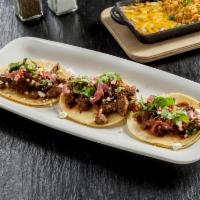 Carne Asada Tacos · -	Three grilled steak tacos topped with picked onions and smoked salsa, queso fresco and cil...