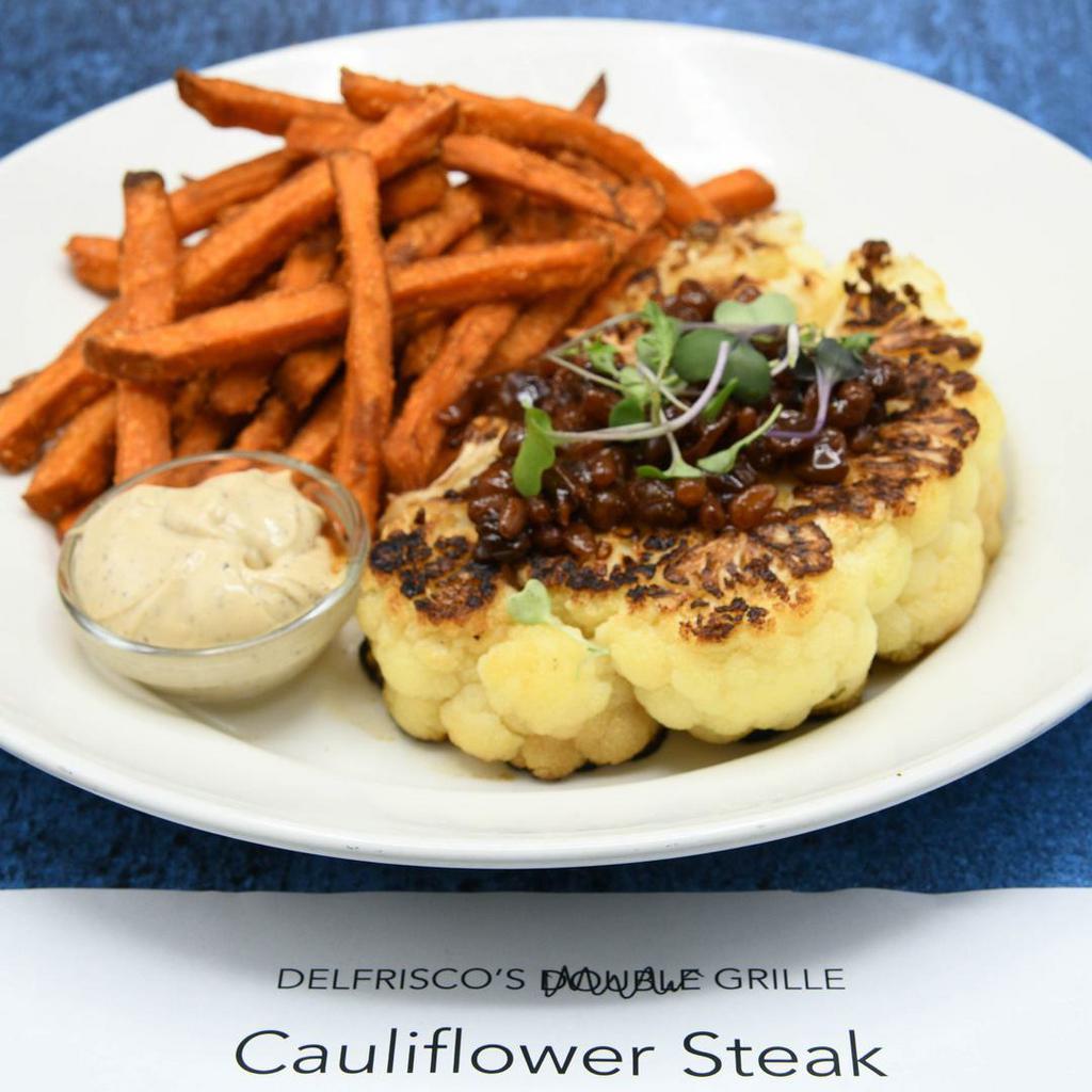Cauliflower Steak · Contains Nuts, Vegetarian. Roasted cauliflower, golden raisin agrodolce, black garlic aioli,  choice of side.