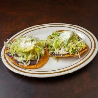 Chicken Tostada · Crunchy tortilla with refried beans, lettuce, avocado, Cotija cheese & sour cream.