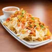 Buffalo Chicken Nachos · Tortilla chips piled high with queso, tomatoes, scallions, sour cream, cheddar jack cheese, ...