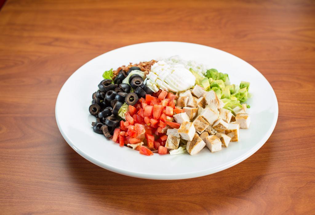 Cobb Salad · A tower of fresh greens topped with diced grilled chicken, crumbled bleu cheese, bacon crumbles, hard-boiled egg, avocado, tomatoes, and black olives. Served with ranch dressing.