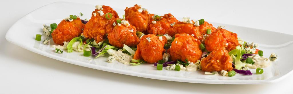 Buffalo Cauliflower · Lightly battered and fried cauliflower florets tossed in our buffalo sauce on a bed of bleu cheese dressing and crunchy cabbage. Topped with crumbled bleu cheese and freshly sliced scallions. Vegetarian and spicy.