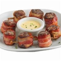 Bacon Wrapped Steak Skewers* · Tender, grilled steak wrapped in savory, smoked bacon. Served with our bleu cheese cream sau...