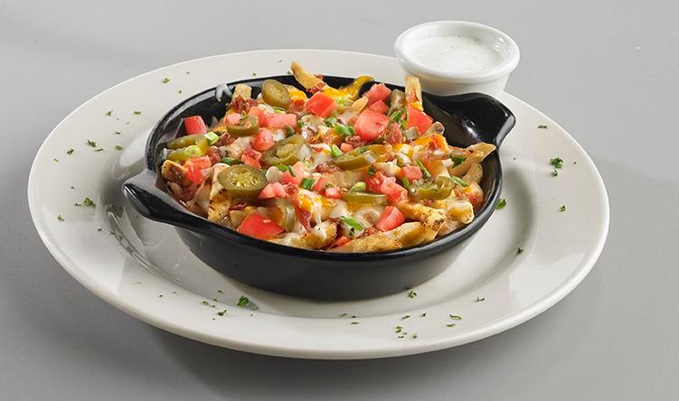 Loaded Cheese Fries · Fries smothered in our rich queso topped with fresh jalapeños, diced tomatoes, and bacon. Garnished with green onion and parsley.