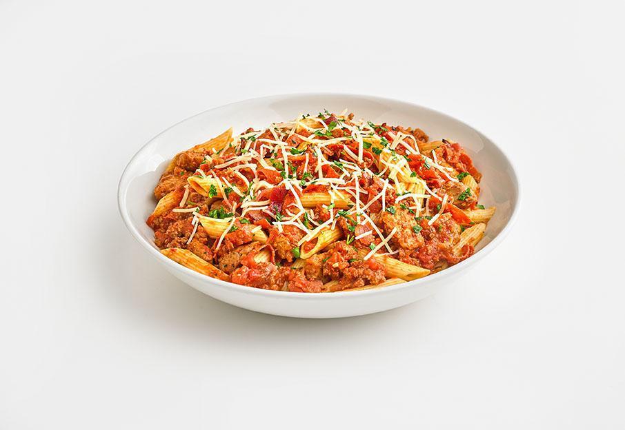 Hungry Carnivore Pasta · Italian sausage, diced meatballs, bacon, pepperoni, and penne pasta smothered in Bolognese sauce.