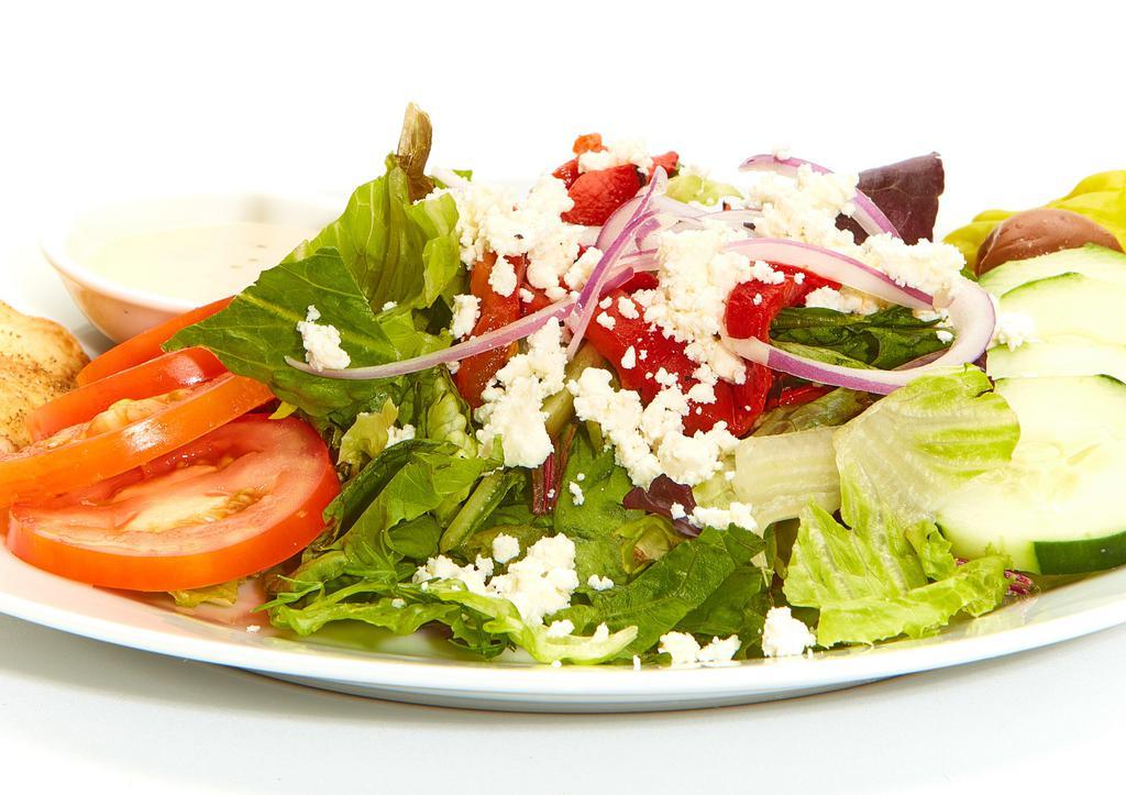 Greek Salad · Fresh mixed lettuces, tomatoes, cucumbers, roasted red peppers, red onions, feta, pepperoncini, Kalamata olives, a baked pita chip, and Greek dressing. 