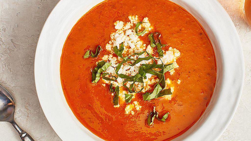 Bowl of Tomato Basil Soup · Made with fresh tomatoes, basil, onions, garlic, and thyme. Topped with feta cheese and fresh basil and comes with Baked Pita.