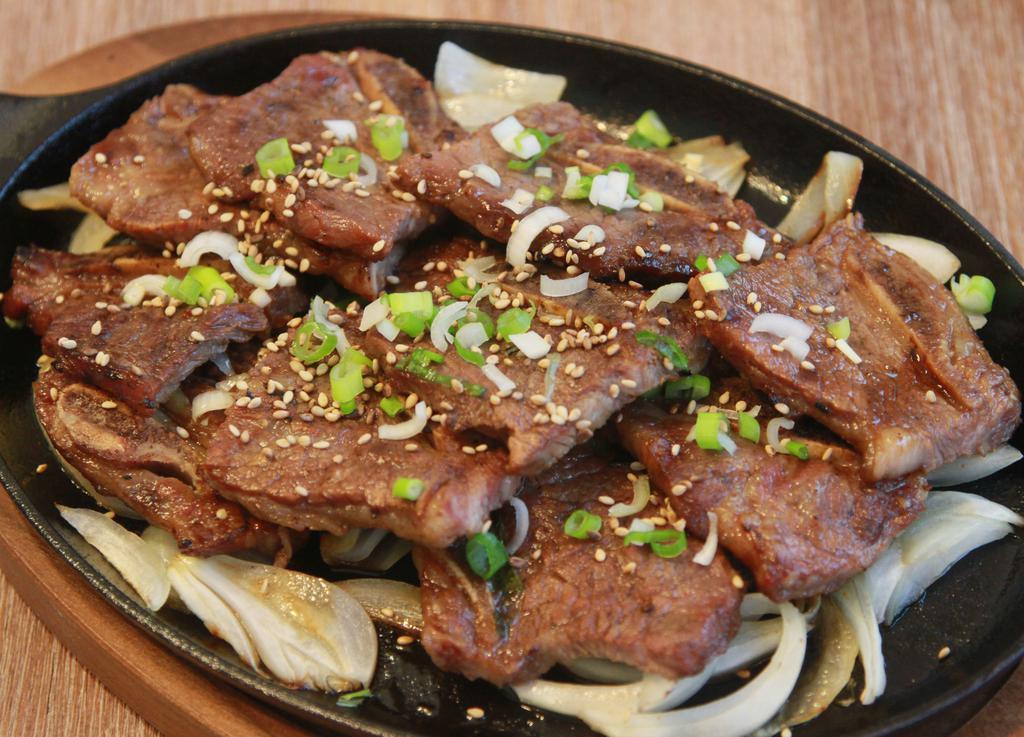 Beef Short Ribs (Gal Bi) · Korean style grilled short ribs. One of the most popular dishes in Korean barbecue. They are marinated in sweet and savory sauce. Served with rice and salad.
