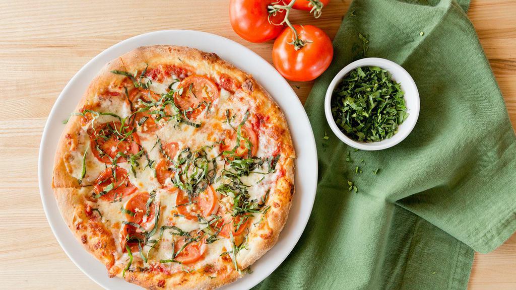 Margherita Pizza · Marinara sauce, mozzarella, tomatoes, fresh basil and roasted garlic.