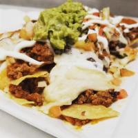 Nachos · Chips layered with beans, your choice of chicken, ground beef, topped off with chihuahua che...