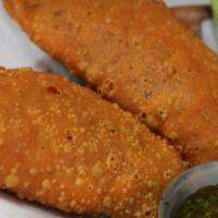 Empanadas · 2 pastry empanadas filled with creole seasoned ground beef. Served with a side of chimichurr...