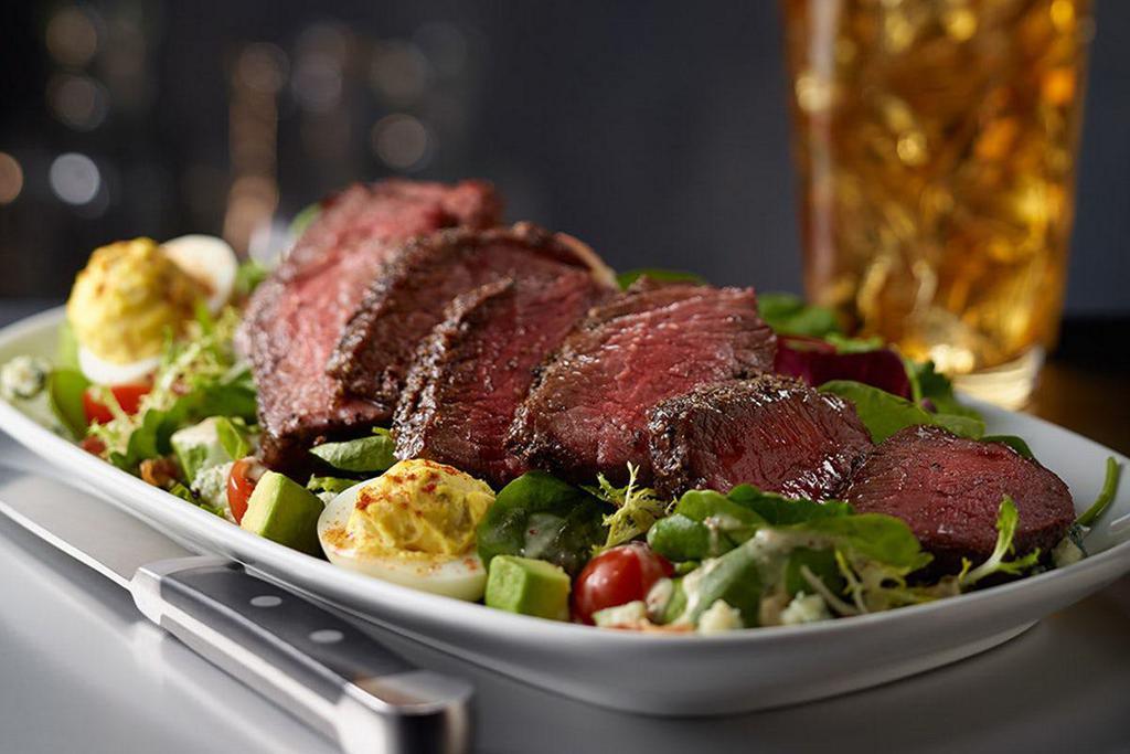 STEAKHOUSE SALAD WITH STEAK · Prime Strip Steak, Mixed Greens, Avocado, Applewood Smoked Bacon, Hard-Boiled Egg, Parmesan, Blue Cheese, Cherry Tomatoes, Suggested Dressing - Sweet Basil Vinaigrette