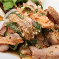 Nam Tok น้ำตก · Slice of grilled pork or beef salad with chille, roasted rice, fish sauce, mint.