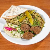 Jordanian Vegetarian Plate · M'jadara, baba ghanoush, and 3 falafels. Garnished with pickles and turnips. Served with a w...