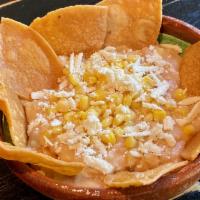 Frijoles · Refried mayocoba beans with yellow corn, topped with queso fresco, served with house made to...