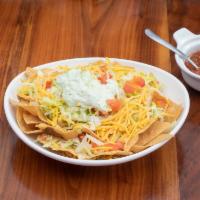 Martha’s Chips · Chips topped with rice, beans, chile verde, lettuce, cheese, guacamole dip and olives. Add c...