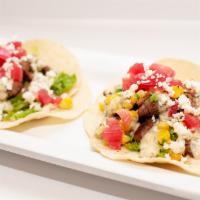 Asada Street Tacos · Soft corn tortillas, grilled carne asada, cilantro, shredded lettuce, topped with roasted co...
