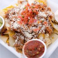 Chipotle Chicken Nachos · Layers of freshly made white corn tortilla chips, cheddar and pepper jack cheeses topped wit...