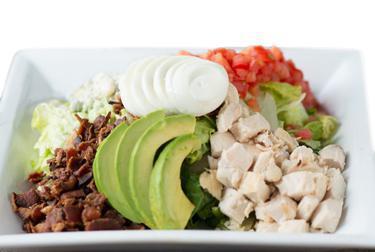 Chef's Chopped Cobb · Chilled romaine lettuce topped with diced chicken, applewood smoked bacon, bleu cheese crumbles, sliced hard boiled eggs, avocado, and diced Roma tomatoes.