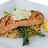 Grilled Atlantic Salmon · Broiled salmon filet topped with citrus butter on a bed of rice pilaf and served with grille...
