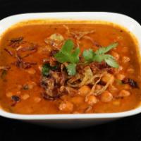 Channa Masala · Channa (chickpeas) cooked in a tomato and onion base, garnished with raw onions and cilantro