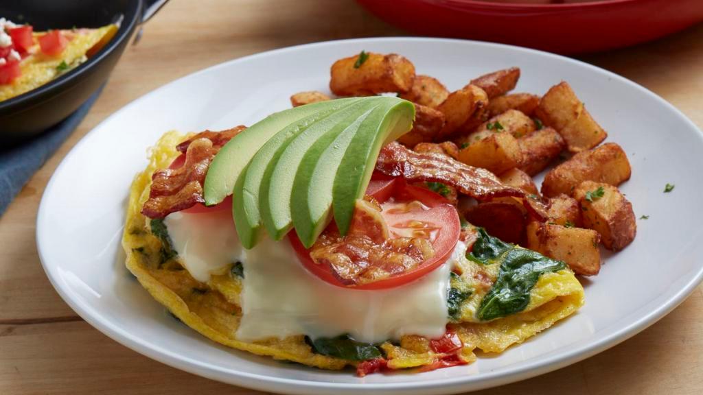 Bacon Avocado Omelet · Three eggs, hickory-smoked bacon, spinach, tomatoes, Monterey jack cheese and avocado. Served with roasted potatoes.