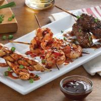 Brochette Trio · Skewers of grilled spicy peanut chicken, teriyaki shrimp and ground beef with red wine sauce.