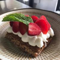 Strawberry Pavlova · Almond dacquoise topped with dulce de leche, Chantilly and fresh sliced strawberries.