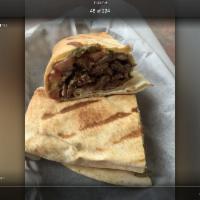 Beef Shawarma Sandwich · Thinly sliced beef and lamb, cooked on a slow rotisserie, served with tomatoes, pickles and ...