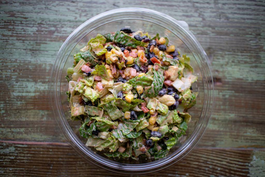 Chopped Southwest Salad · Chopped Romaine, bacon, black beans, corn, avocado, and grape tomatoes tossed with a pepper-lime dressing.