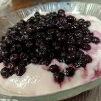 Yogurt Parfait · Bowl of strawberry yogurt topped with granola and wild maine blueberries.