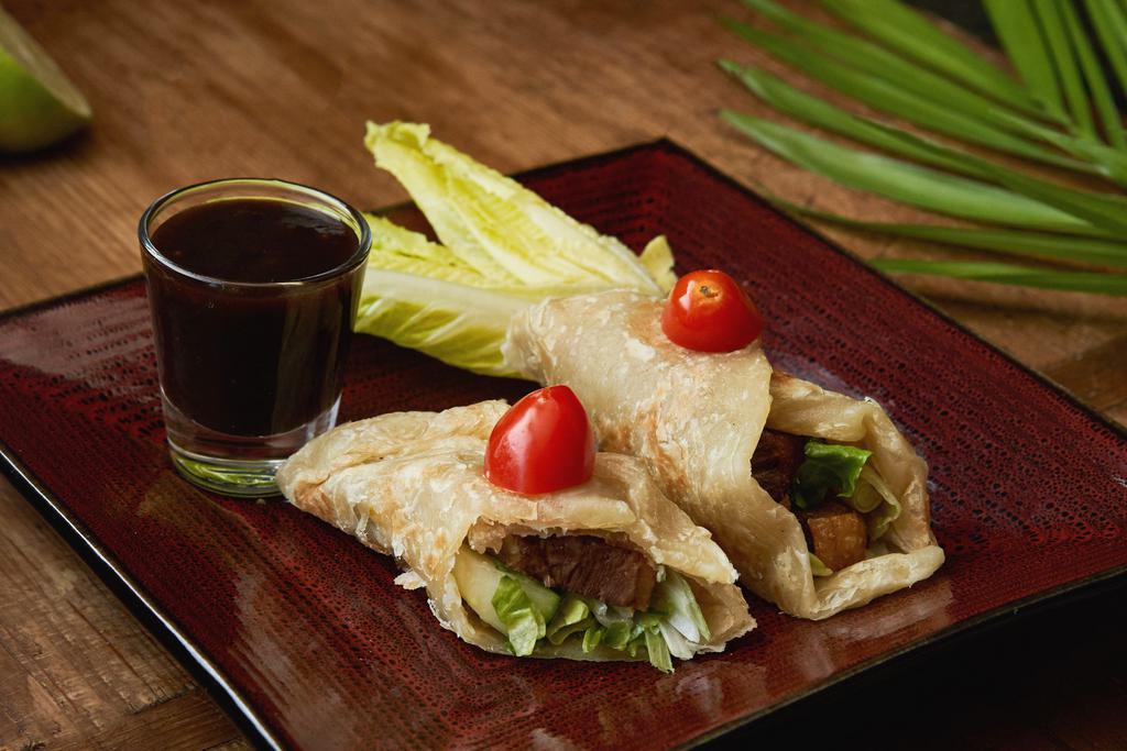 Winter Duck Roll · Homemade crispy duck roll up with roti naan, cucumber, and scallion with tamarind sauce.