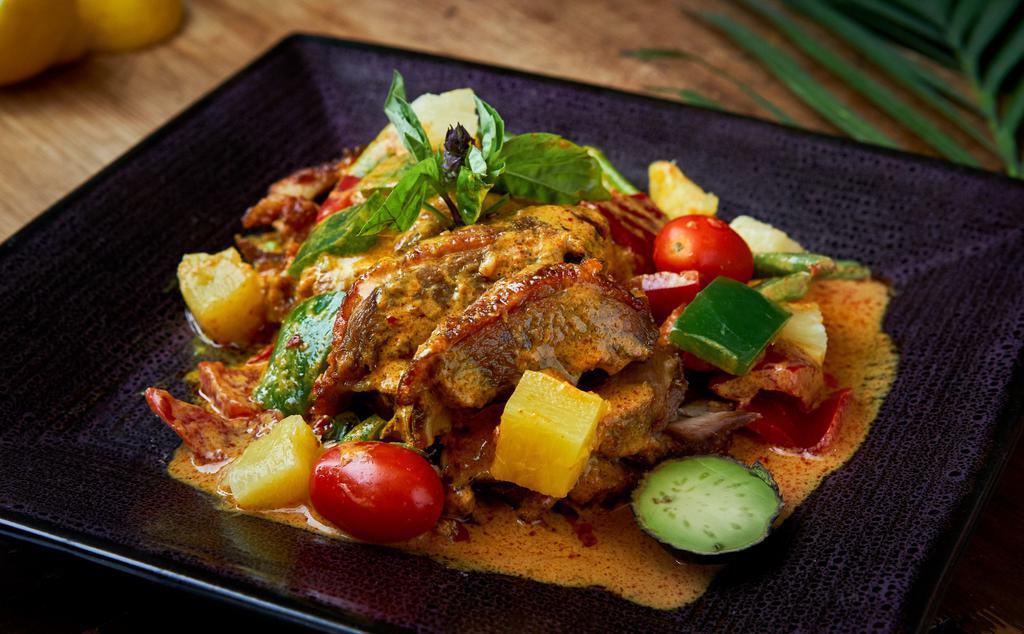 Duck Pineapple Curry · Served hot and spicy. Crispy duck with tomato, pineapple, hot pepper, and basil in red curry. Served with white rice.