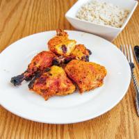Tandoori Chicken · Tender chicken marinated in yogurt and spices then baked on skewers in our clay oven.