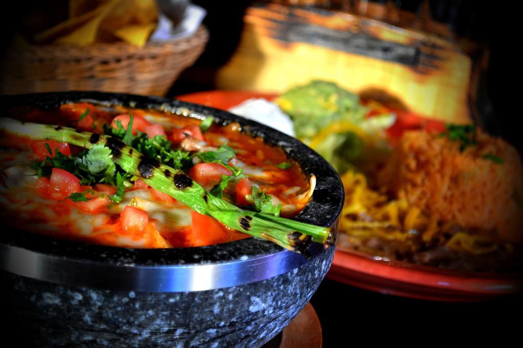 Mazatlan Molcajete · Molcajete slices of Angus top sirloin steak and chicken breast both sauteed in onions, green and red peppers served with special molcajete sauce and topped with Monterey Jack cheese. Served with rice, beans, guacamole, sour cream and warm tortillas.