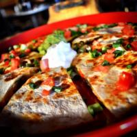 Quesadilla · Flour tortilla with melted cheese, sauteed vegetables, guacamole and sour cream.