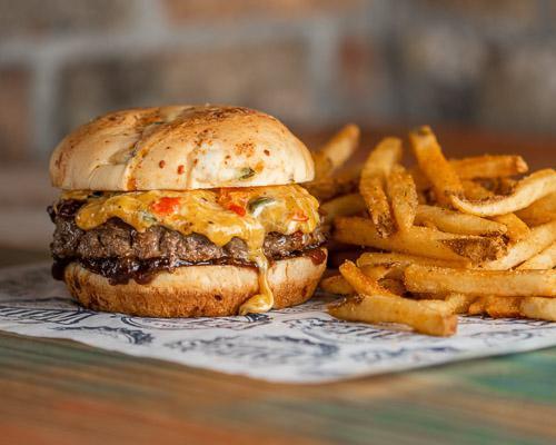 Cheddar Pepper Burger · Half pound burger with caramelized onions and roasted pepper cheese mix on a jalapeno cheddar bun served with choice of side.
