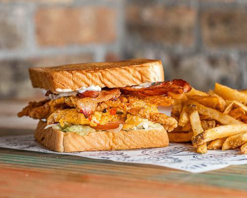 Texas Fried Chicken Club · Fried chicken breast with jalapeno mayo, bacon, lettuce, tomato, and roasted pepper cheese mix on Texas toast served with choice of side.