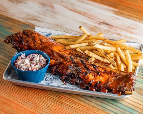Baby Back Ribs · Full or half rack of ribs smothered in BBQ sauce and served with choice of two sides.