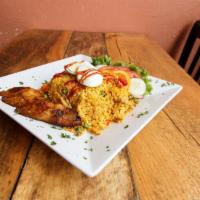 Arroz con Pollo · Rice with shredded chicken and vegetables served with sweet plantains, eggs and green salad.