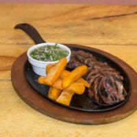 Entrana · Grilled skirt steak served with fried cassava, salad, rice and beans.